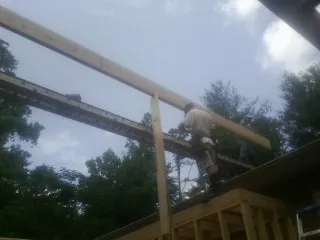 Carpenter setting a ridge beam over a new addition frame — Ice Dam Removal by Roofing Brothers in Wind Gap