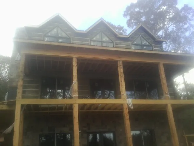 Dormers and porch framing on a large log home under construction — Roof Coating work by our crew in Wind Gap