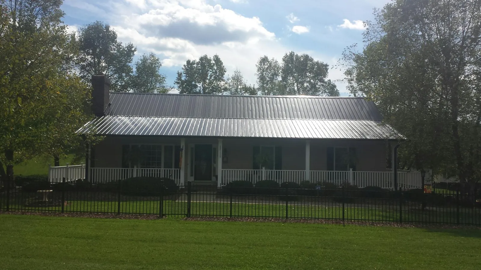 Gray metal roof on a brick ranch with a full width front porch — Gutter Guard Installation work by our crew in Wind Gap