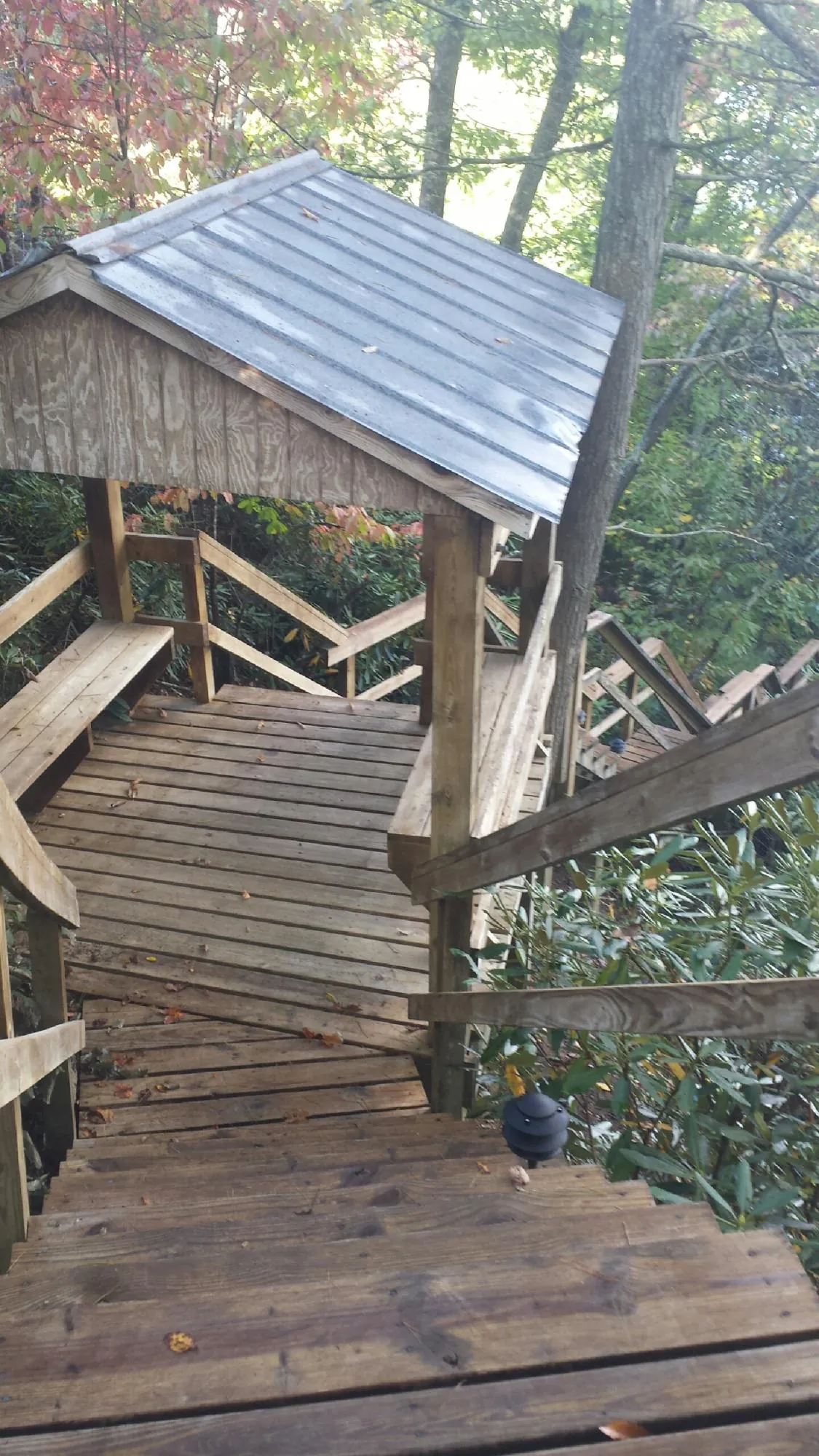 Metal roofed shelter over wooden steps on a wooded walkway — Skylight Repair & Installation work by our crew in Wind Gap